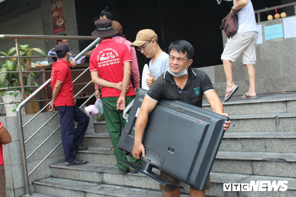 Anh Trần Đức Cường (cư dân chung cư Carina Plaza) cho biết: “Những ngày qua, gia đình tôi huy động thêm anh em đến vận chuyển nhiều đồ đạc trong nhà đến chỗ mới để phục vụ sinh hoạt, đồng thời để chủ đầu tư sửa chữa lại. Sau vụ cháy, nhà tôi chỉ bị khói, vết đen bám vào tường đổi màu chứ không thiệt hại gì cả”. Ảnh: Mồ hôi nhễ nhãi, khuôn mặt mệt mỏi của cư dân chung cư Carina khi chuyển đồ về chỗ ở tạm.