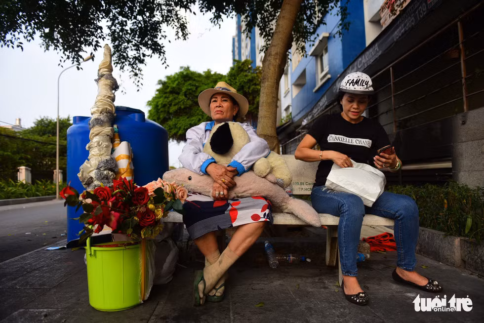 Cô Tuyết (bìa trái), sinh sống tại block A của chung cư Carina Plaza, đã phải chi ra 4 triệu đồng thuê 2 xe ba gác chở đồ ra khỏi Carina Plaza, đồ đạc sẽ được chuyển qua chỗ ở tạm tại chung cư City Gate phía đối diện.
