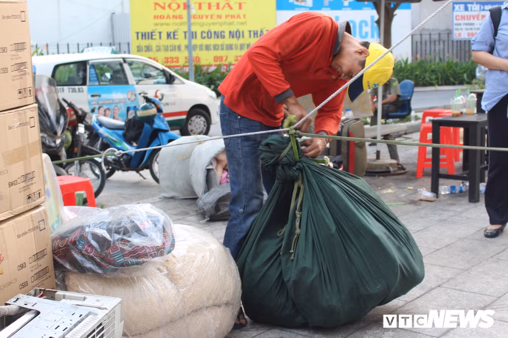 Nhiều người sống ở tầng cao phải dùng ròng rọc để vận chuyển đồ đạc xuống dưới. Còn những cư dân ở tầng thấp thì vận chuyển bằng tay. Mặc dù rất mệt mỏi nhưng ai cũng muốn vận chuyển thật nhanh để ổn định cuộc sống sau vụ cháy thảm họa. Ảnh: Hàng hóa được gói vào chăn, buộc lại rồi thả theo ròng rọc xuống sân chung cư.