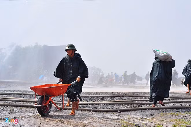 Cán bộ, chiến sĩ vận chuyển các bao đất đến khu vực đê bị vỡ để khắc phục. Đồng thời, sửa chữa những ngôi nhà bị hư hỏng.