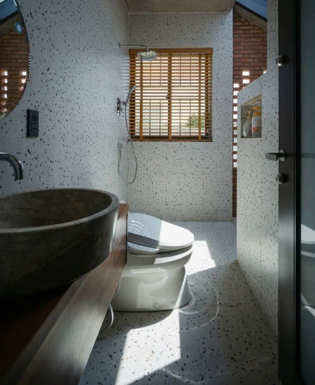 Phòng vệ sinh trông hiện đại hơn với việc sử dụng gạch terrazzo để ốp tường và lát nền (nguồn: Archdaily, ảnh: Quang Trần) Ba phòng ngủ bố trí trên cùng 1 tầng và xoay quanh khu sinh hoạt chung – nơi các thành viên gia đình có thể ngồi cạnh nhau và ngắm bầu trời đêm thông qua ô mái kính. Tổng diện tích mỗi sàn chỉ vỏn vẹn trong 80 m2.