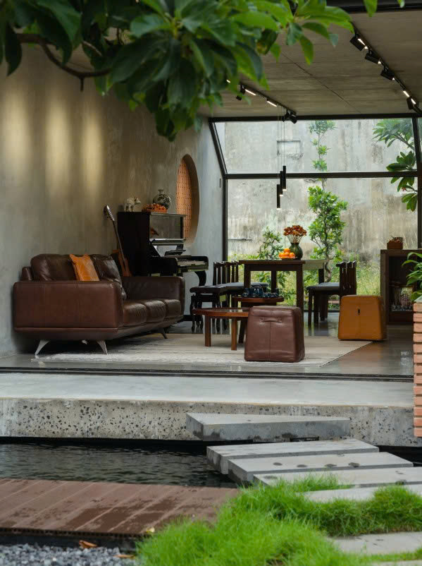 Lối đi bằng bê tông kết nối giữa không gian sinh hoạt chung ở tầng 1 và sân vườn (nguồn: Archdaily, ảnh: Quang Trần)