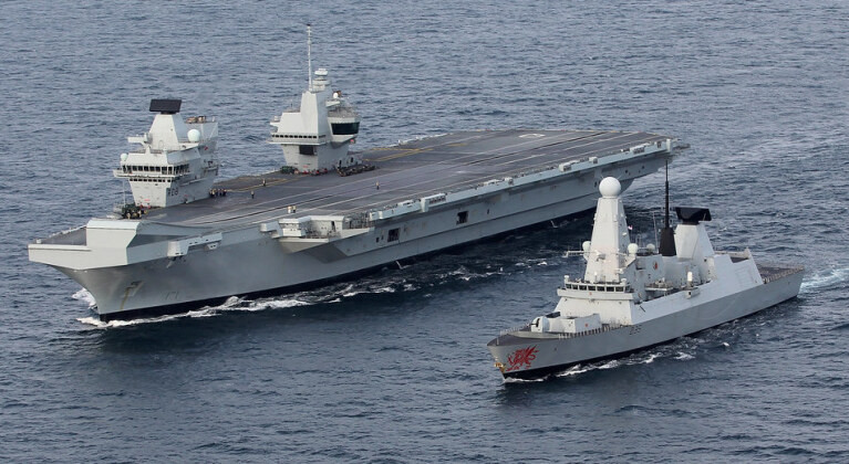 Mặc dù chỉ vừa biên chế hai tàu sân bay là chiếc HMS Queen Elizabeth và chiếc HMS Price of Wales vào năm 2017 và 2019 vừa qua, cùng với đó là hình thành xong cụm tác chiến tàu sân bay HMS Queen Elizabeth vào đầu năm 2021 vừa rồi. Hải quân Anh đang phải đối mặt với việc thiếu thốn trầm trọng đội tàu chiến hộ tống các tàu sân bay này, trong tương lai gần, nếu cho nghỉ hưu những chiếc khu trục hạm Type-45 thì khó khăn này của Hải quân Anh sẽ là càng thêm chồng chất. Ảnh: Tàu khu trục Type-45 hộ tống tàu sân bay HMS Queen Elizabeth của Anh.