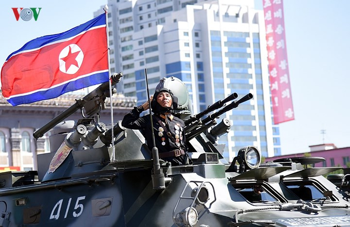 Binh sĩ Triều Tiên trên xe đứng nghiêm, giơ tay chào trong lúc đoàn xe di chuyển qua lễ đài.