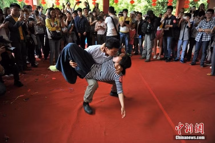 Đây là một hình ảnh trong "cuộc thi hôn" kỳ lạ được tổ chức tại công viên Hắc Long Đàm ở Côn Minh, Vân Nam, miền Nam Trung Quốc trong dịp Quốc tế Lao động 1/5.