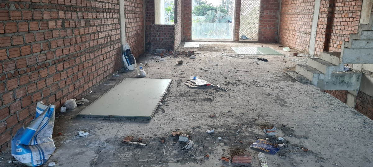 Bên trong các căn shophouse vừa mới được xây thô là ngổn ngang rác thải. 