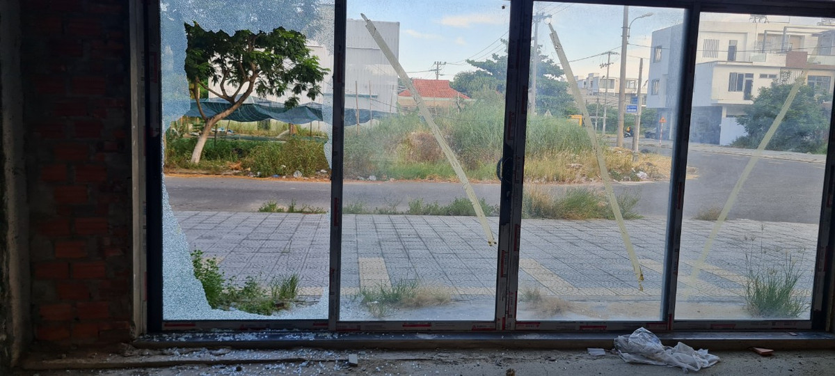 Bên kia đường, cỏ dại đã mọc cao quá đầu trên những khu đất trống. Bên này, cửa kính vỡ vụn ở những căn shophouse bỏ hoang lâu ngày.