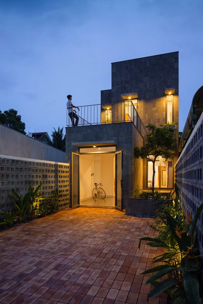 Kiến trúc sư sử dụng đá tự nhiên, khối bê tông và gạch thô để làm mặt tiền tạo sự đơn giản và gần gũi, không bị quá nổi bật so với những ngôi nhà xung quanh.