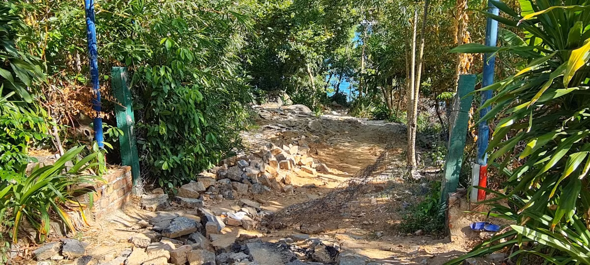 Hàng rào lưới rỉ sét nằm chỏng chơ ngay cạnh đống gạch đá ngổn ngang.