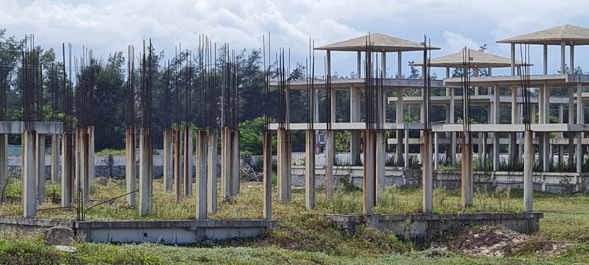 Sắt thép hoen gỉ trên những trụ bê tông nham nhở, chưa rõ hình hài.