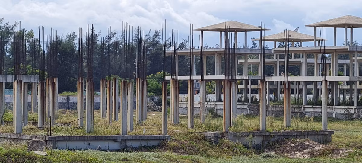 Sắt thép hoen gỉ trên những trụ bê tông nham nhở, chưa rõ hình hài.