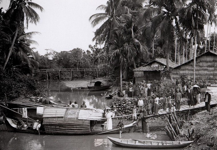 Linh mục thổi kèn để quy tụ giáo dân tại một xóm đạo bên kênh rạch ở Sài Gòn năm 1904. Ảnh: Aavh.org.