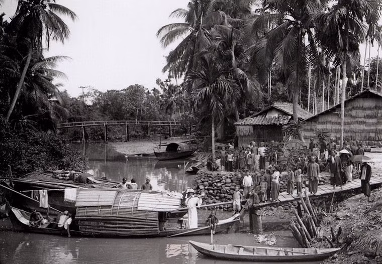 Linh mục thổi kèn để quy tụ giáo dân tại một xóm đạo bên kênh rạch ở Sài Gòn năm 1904. Ảnh: Aavh.org.