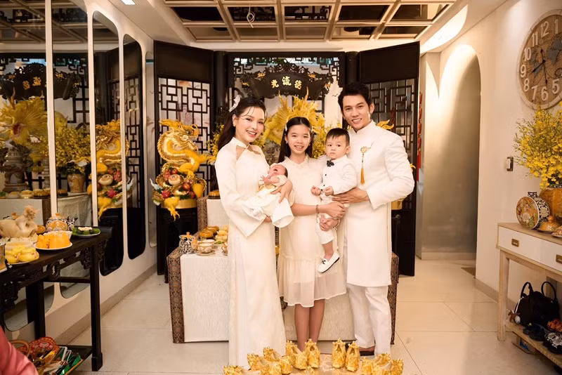 Gia đình Lý Bình mặc trang phục tông trắng trong tiệc đầy tháng của bé Loka.