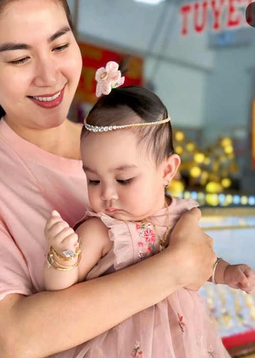 Kha Ly khoe ảnh hài hước của chồng con ngày vía Thần Tài. "Mùng 10 vía Thần Tài, con với ba con không có gì ngoài vàng đeo đỏ người, hai ba con thương chúc cho ông bà cô chú làm ăn phát tài, vàng đeo đỏ tay nha. Nhưng con nói nhỏ cô chú nghe ba con đeo vàng giả đó", Kha Ly chia sẻ. Ảnh: FB Kha Ly.