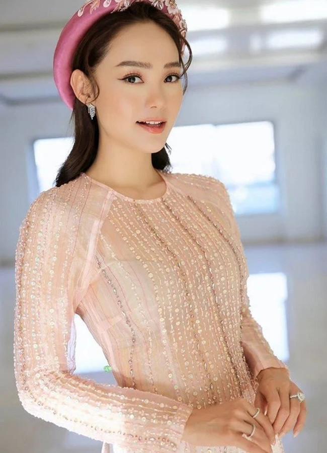 Minh Hằng diện áo dài truyền thống với gam hồng pastel tưởng kín đáo nhưng lại để lộ áo trong.