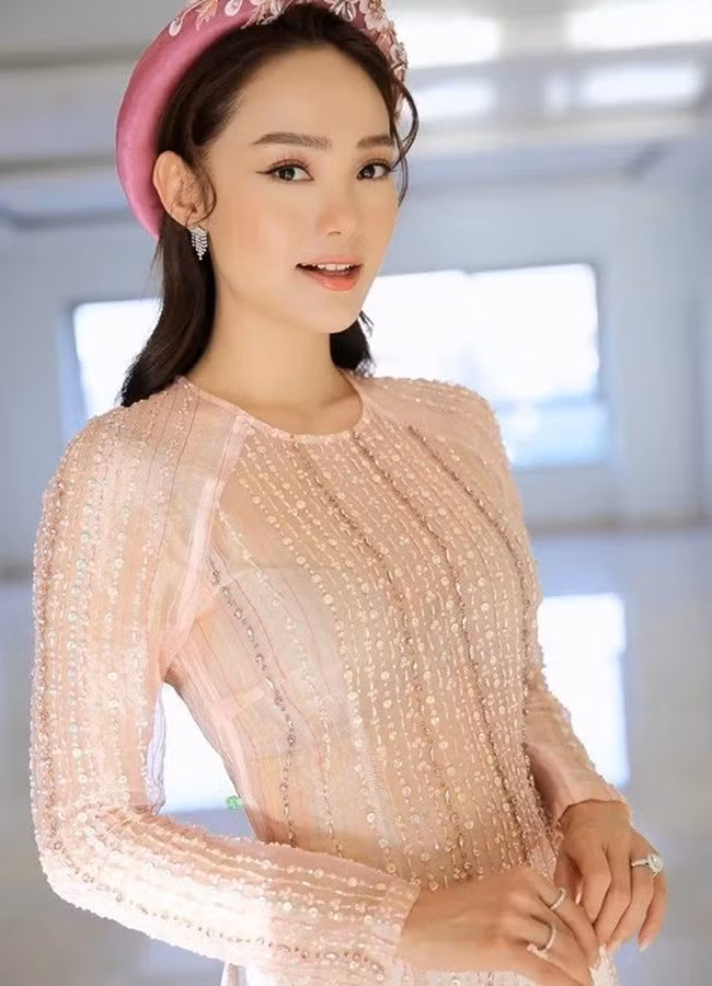 Minh Hằng diện áo dài truyền thống với gam hồng pastel tưởng kín đáo nhưng lại để lộ áo trong.
