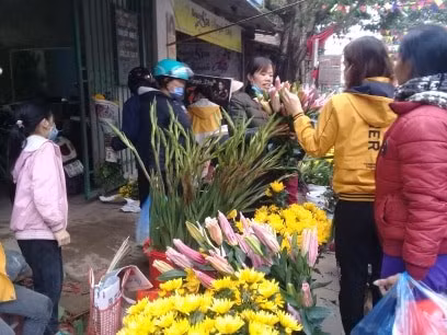 Quần bán hoa của chị Nguyễn Thị Tình tại Chợ Ngô Xá, Cẩm Khê, (Phú Thọ) tấp nập người đến mua hoa.