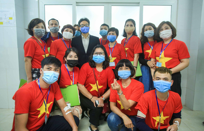 Phó Thủ tướng Vũ Đức Đam chụp ảnh cùng một số tình nguyện vừa tiêm xong vắc-xin phòng COVID-19. (Ảnh: Người lao động)