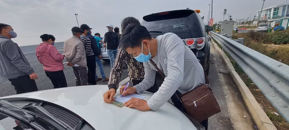 Nhiều tài xế phải viết tờ khai báo y tế luôn trên mui xe vì không có chỗ ngồi.