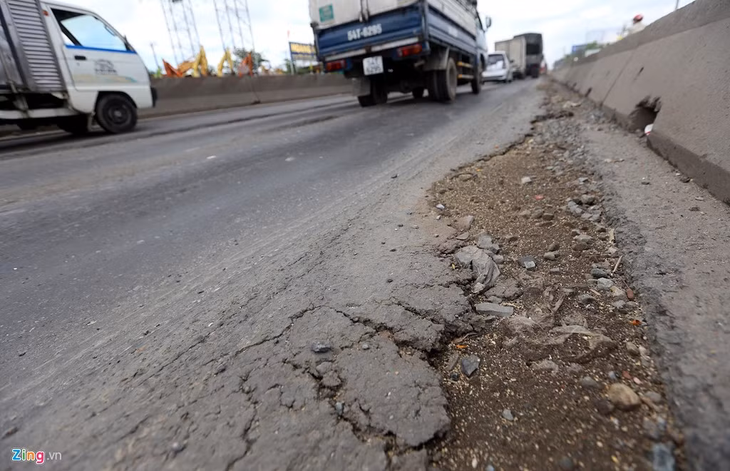 Những phần trồi lên này xuất hiện nhiều vết cà từ những chiếc xe có gầm thấp. Một số vị trí khác nhựa đường nứt nẻ, bong tróc ùn lên phần đất đá phía dưới. 