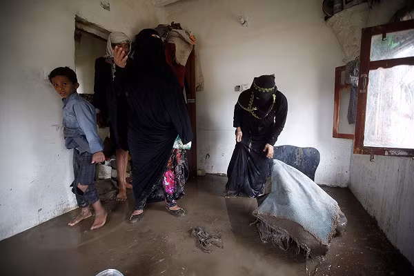 Người dân thu dọn những đồ vật trong ngôi nhà đầy bùn đất ở ngoại ô Sanaa.