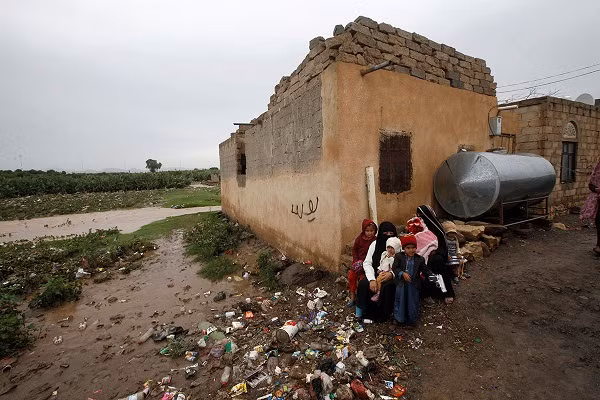 Một gia đình ngồi bên ngoài ngôi nhà bị ngập của họ ở vùng ngoại ô Sanaa.