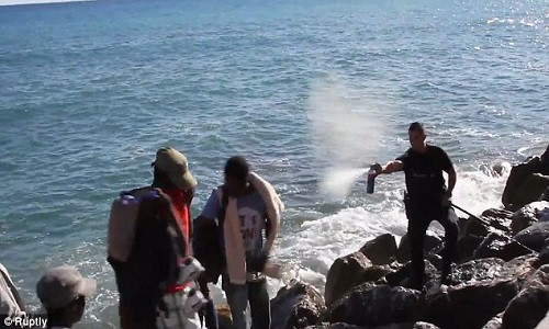 Hình ảnh cảnh sát Pháp xịt hơi cay vào các di dân đến từ Châu Phi.