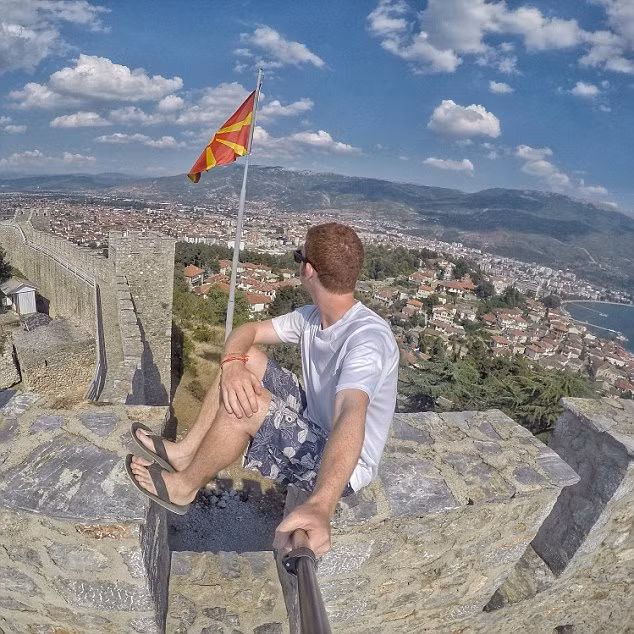 Drew ngồi trên một tòa thành và nhìn ra thị trấn biển ở Macedonia.