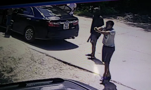 Một người từ trên ô tô bước xuống cầm súng ngắn bắn nhiều phát về phía gia đình ông Trịnh Ngọc Đỉnh - Ảnh cắt từ camera.