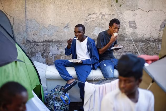 Các di dân tranh thủ ăn...