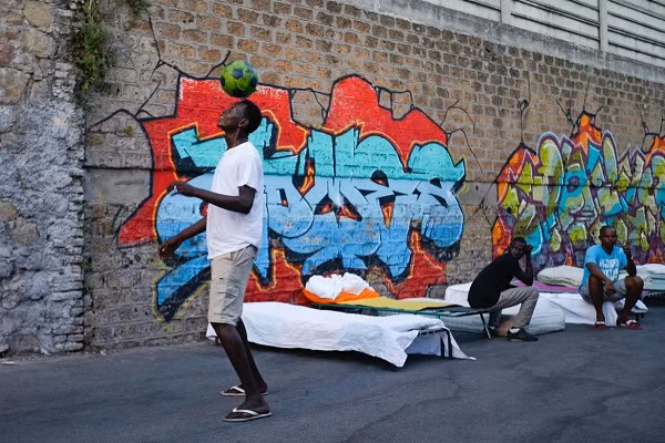 Một di dân tâng bóng trên đường phố.