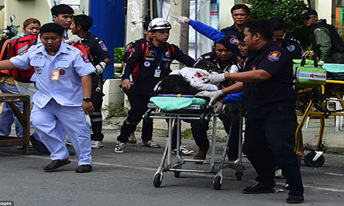 Hai vụ nổ bom đầu tiên xảy ra trên đường phố đông đúc tại khu nghỉ dưỡng Hua Hin vào khoảng 10h20 tối 11/8, khiến ít nhất 1 phụ nữ Thái thiệt mạng và 21 người khác bị thương. Ảnh: Các nhân viên cứu hộ khẩn trương đưa một người bị thương trong vụ nổ bom ở Hua Hin đến bệnh viện.