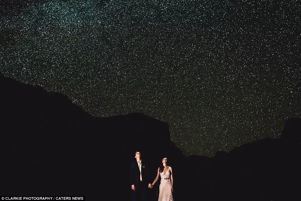 Cặp đôi nắm tay nhau nhìn lên bầu trời đầy sao ở Yosemite, bang California, Mỹ.