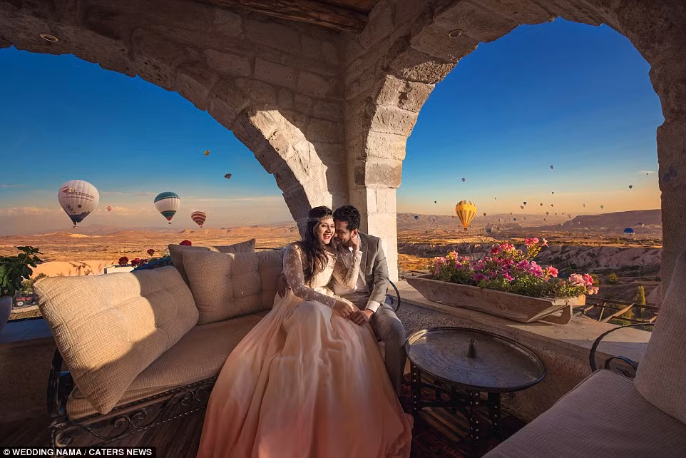 Những quả khinh khí cầu đầy màu sắc trên bầu trời Cappadocia ở Thổ Nhĩ Kỳ làm nền cho cặp cô dâu chú rể.