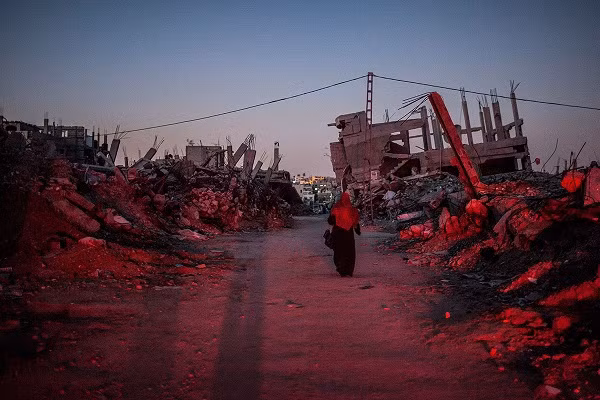 Một phụ nữ đi bộ qua đống đổ nát ở Jabaliya, khu vực bị ảnh hưởng nặng nề trong cuộc chiến tranh năm 2014.