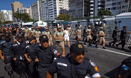 Người rước đuốc trong Thế vận hội Olympic Rio 2016 chạy dọc theo bờ biển Copacabana được đội ngũ an ninh hai bên theo sát bảo vệ nghiêm ngặt ngày 5/8/2016.