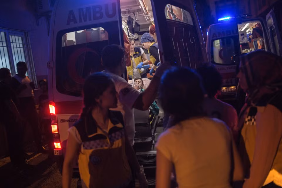 Các nhân viên y tế đưa một người đàn ông bị thương lên xe cấp cứu.