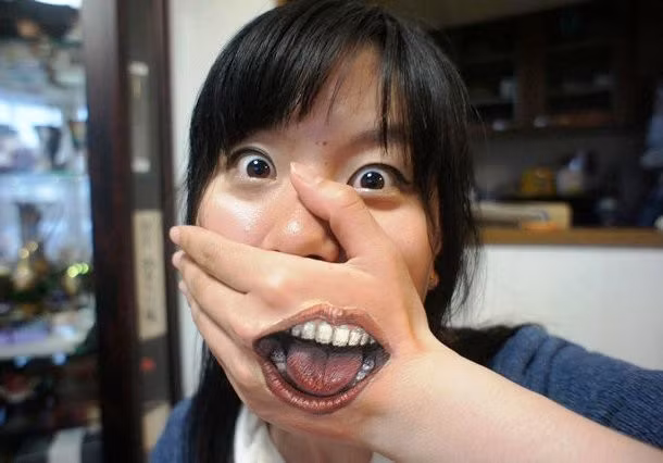 Kinh ngạc về tài năng vẽ tranh trên cơ thể khiến người xem dường như có cảm giác rằng miệng của cô gái ở trên bàn tay.