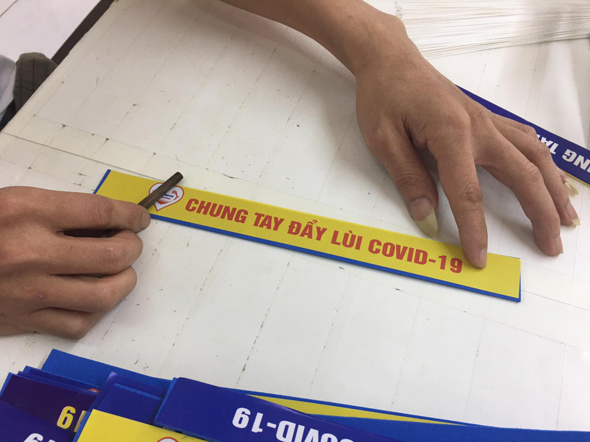 Các học viên cai nghiện gắn chữ "Chung tay đẩy lùi COVID-19" lên kính chống giọt bắn.