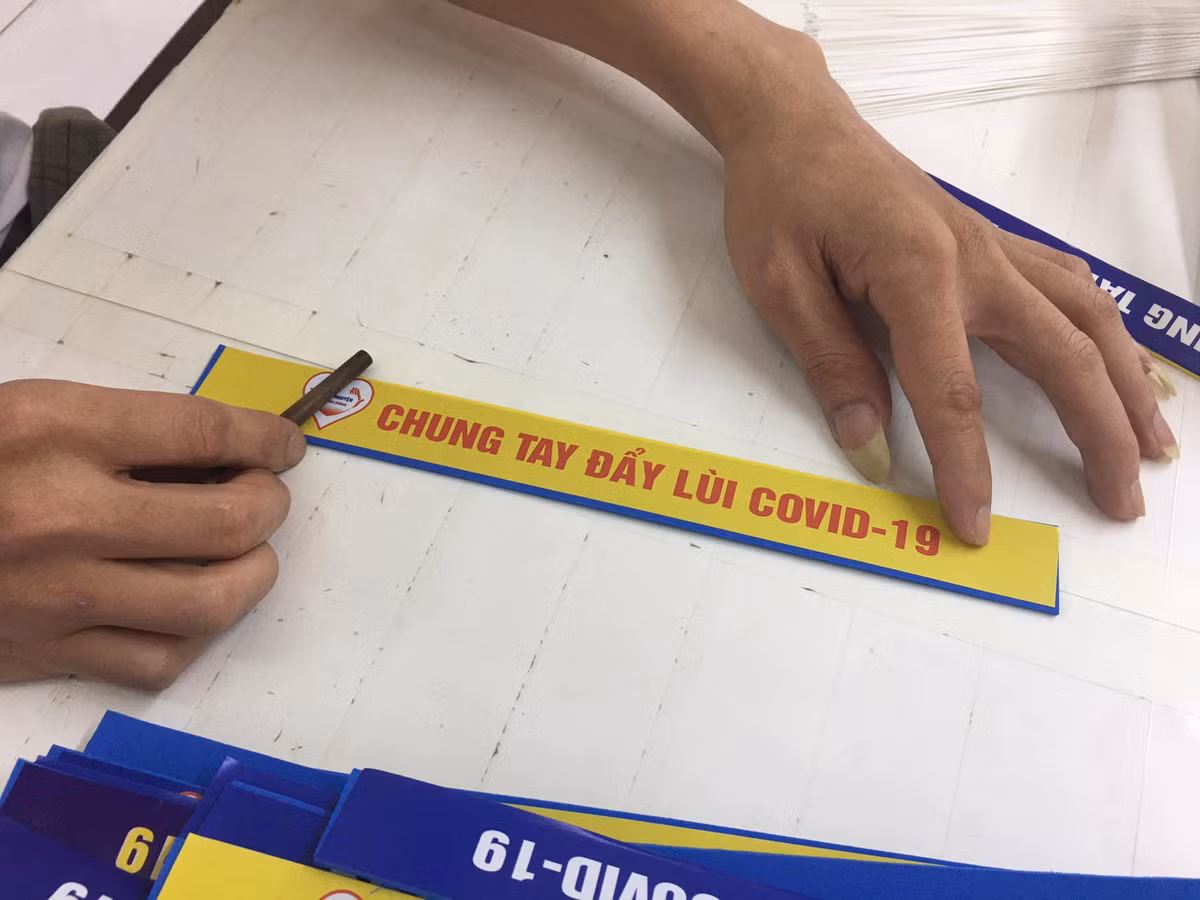Các học viên cai nghiện gắn chữ "Chung tay đẩy lùi COVID-19" lên kính chống giọt bắn.