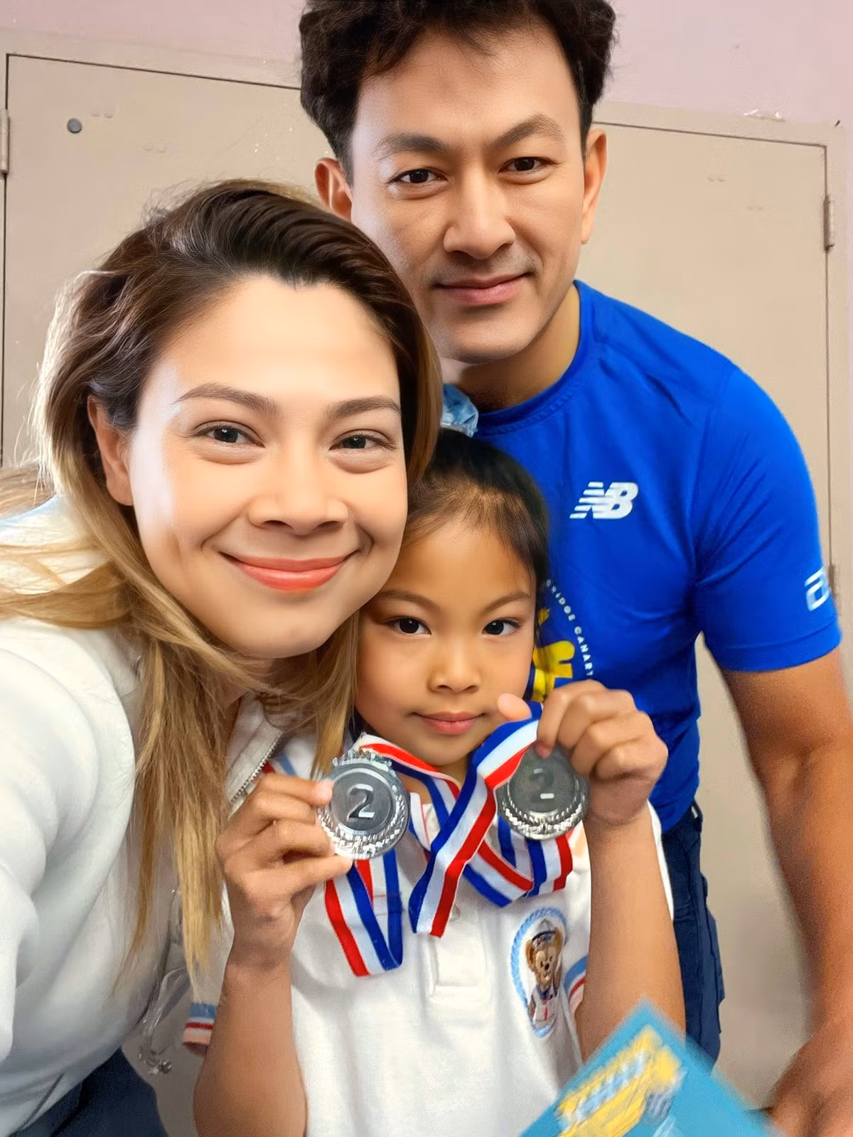 Vợ chồng ca sĩ Thanh Thảo dậy sớm đưa con gái đến trường nhận hai huy chương chạy bộ, "cạnh tranh thành tích với papa". Ảnh: FB Thanh Thảo