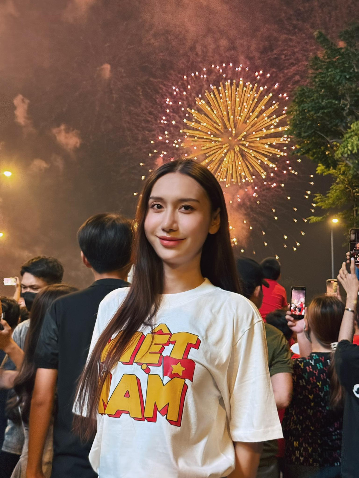 Nữ ca sĩ Lynk Lee (Tô Ngọc Bảo Linh) diện áo in chữ "Việt Nam", chụp ảnh dưới pháo hoa rợp trời. Ảnh: FB Tô Ngọc Bảo Linh
