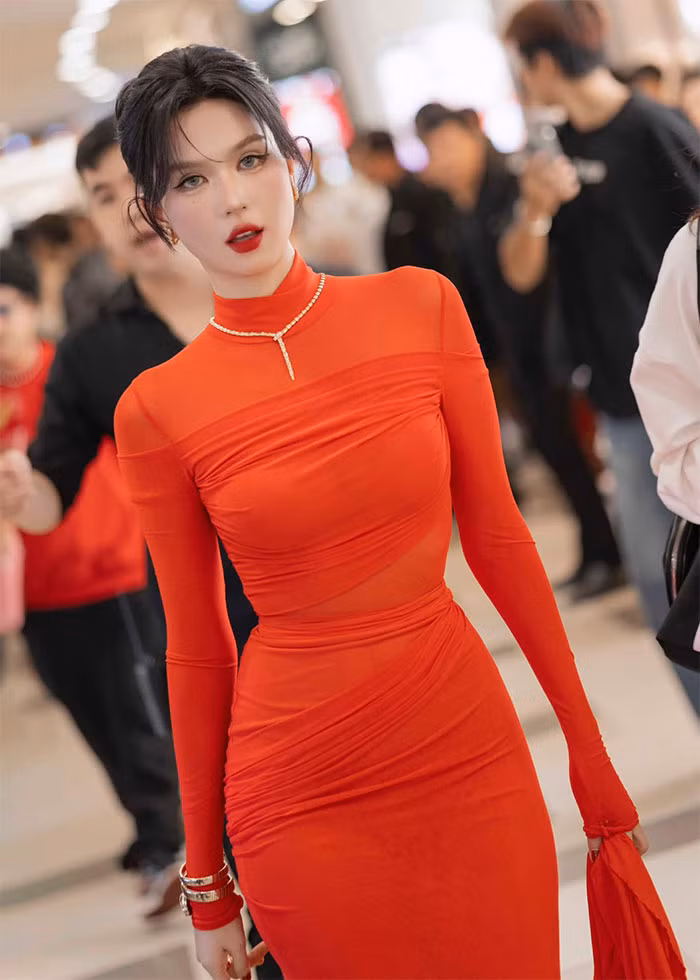 Ngọc Trinh mặc một chiếc váy màu cam kín đáo đi dự sự kiện nhưng vẫn rất quyến rũ bởi chiếc váy ôm sát khoe ba vòng đẹp từng cm của cô.