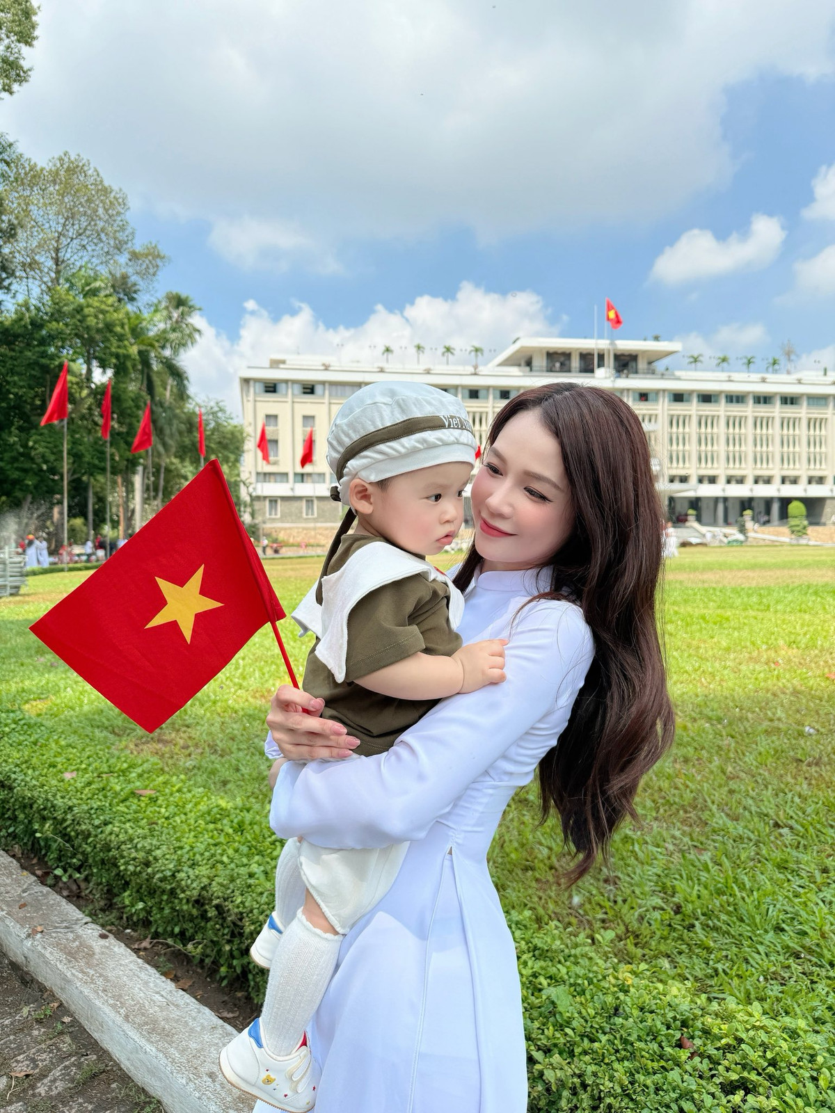 Sam diện áo dài trắng truyền thống, còn cặp song sinh nhà Sam diện trang phục đôi in cờ Tổ quốc. Ảnh: FB Sam