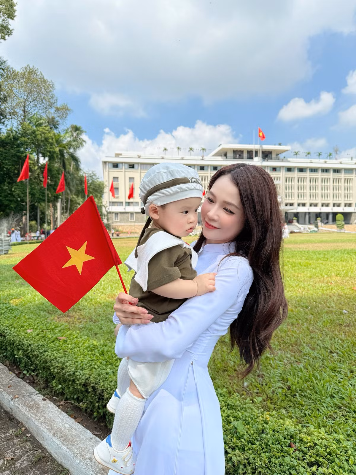 Sam diện áo dài trắng truyền thống, còn cặp song sinh nhà Sam diện trang phục đôi in cờ Tổ quốc. Ảnh: FB Sam