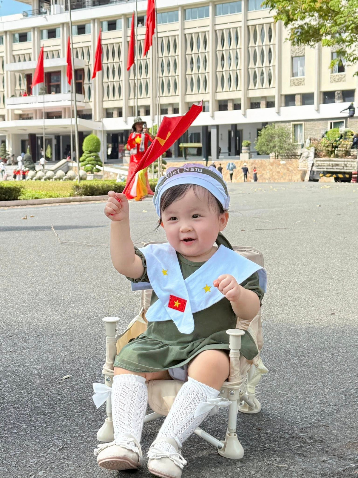 Trên tay cầm cờ đỏ sao vàng, con gái Ijin tươi cười ngộ nghĩnh. Ảnh: FB Sam
