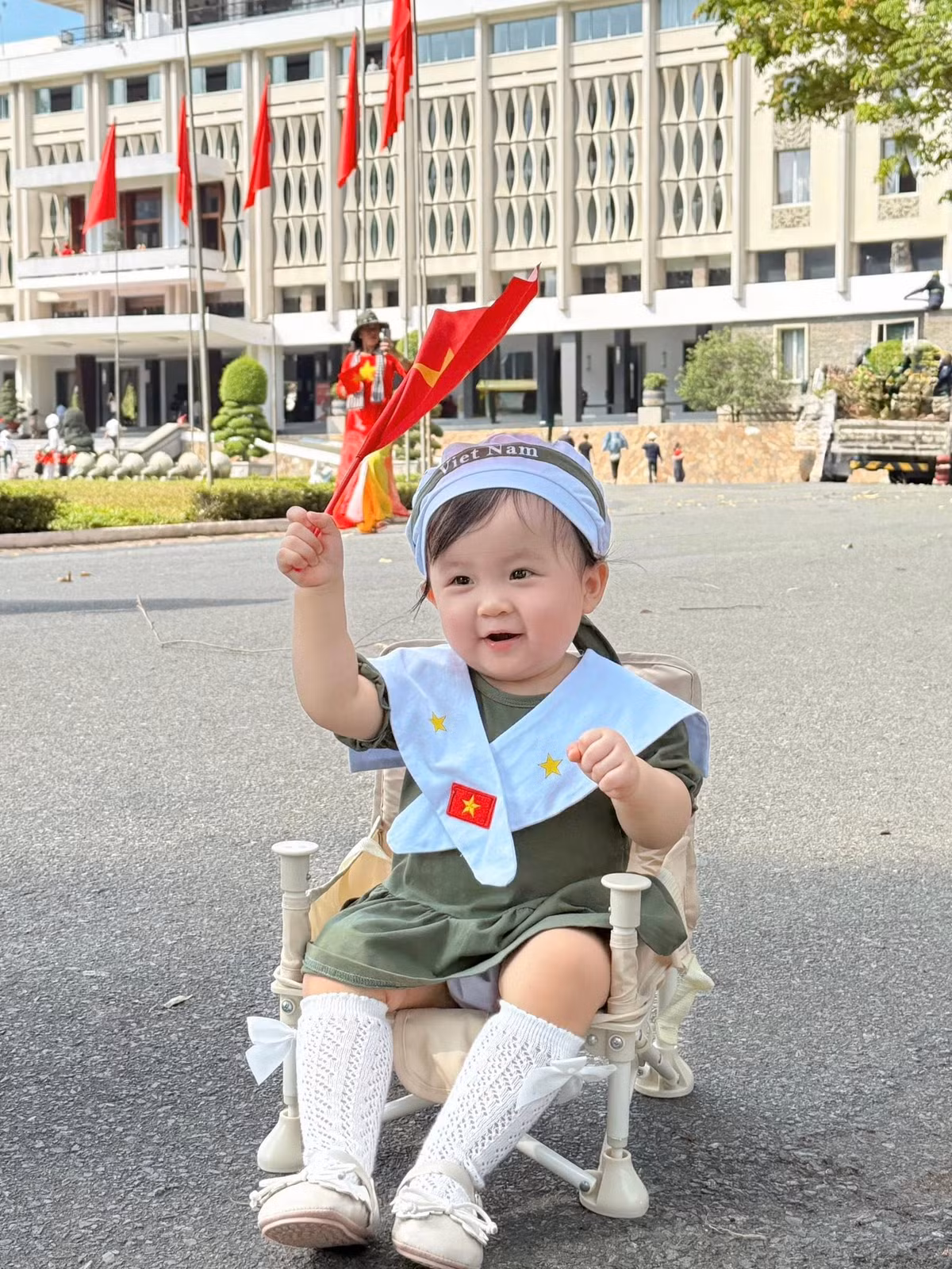 Trên tay cầm cờ đỏ sao vàng, con gái Ijin tươi cười ngộ nghĩnh. Ảnh: FB Sam