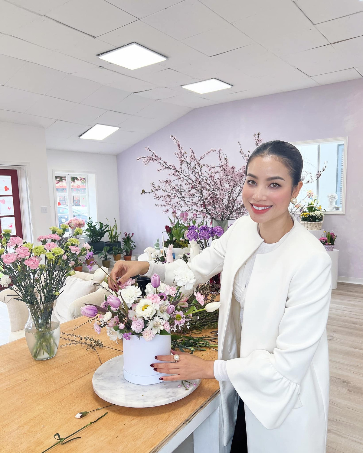 Gần một năm trở lại đây, Phạm Hương lấn sân kinh doanh hoa. Ngoài là bà chủ, nàng hậu còn tự tay cắm hoa cho khách hàng. Mỗi ngày đến chỗ làm, bà mẹ hai con thay đổi phong cách đa dạng. Ảnh: FB Hoa Hậu Phạm Hương