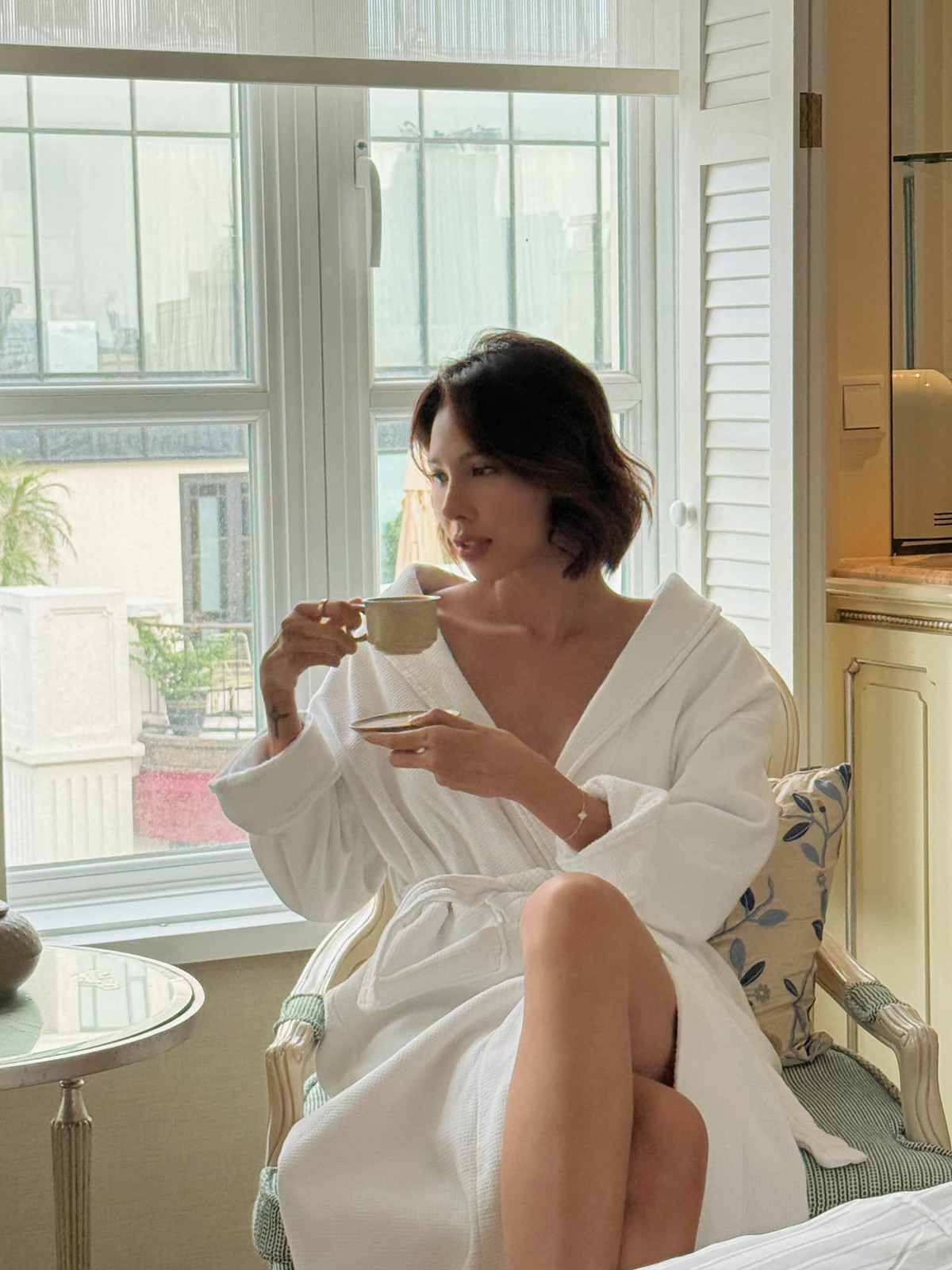 Minh Triệu diện đồ ngủ gợi cảm, tạo dáng với tách trà. Ảnh: FB Pham Dinh Minh Trieu